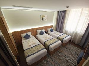 a hotel room with two beds and a window at فندق جادة أجياد Jada Ajyad Hotel in Ajyad