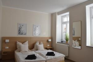a bedroom with a bed with two black towels on it at Pension Alte Flugleitung in Stendal