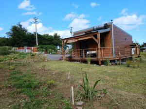 a small house with a porch on a grass field at La cabane au millieu du jardin in Saint-Louis