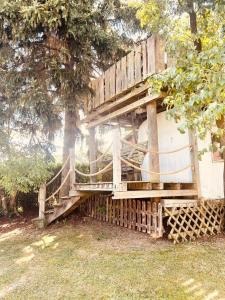 a tree house with a wooden staircase next to a tree at Ferienwohnung Lex in Weiding
