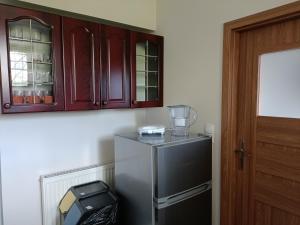 a kitchen with a refrigerator and wooden cabinets at Apartament Orłowo in Gdynia