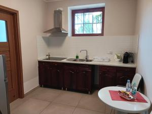a kitchen with a sink and a table and a window at Apartament Orłowo in Gdynia