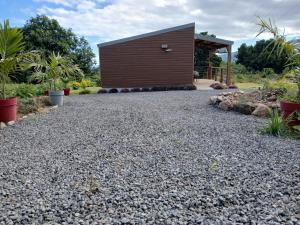 a gravel driveway with a small building in the background at La cabane au millieu du jardin in Saint-Louis