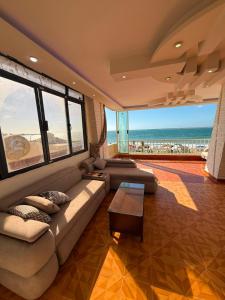 a living room with a couch and a view of the ocean at Direct Beachfront - Sea View 2 bed rooms in Jazīrat al Maskhūţah
