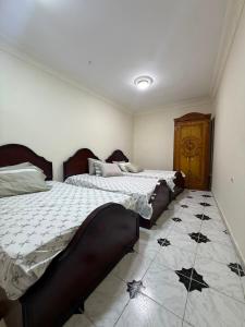 a bedroom with two beds and a tile floor at Direct Beachfront - Sea View 2 bed rooms in Jazīrat al Maskhūţah