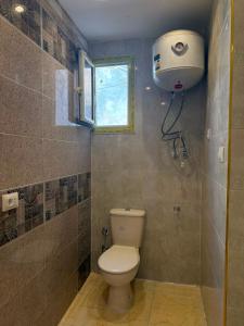 a small bathroom with a toilet and a window at Direct Beachfront - Sea View 2 bed rooms in Jazīrat al Maskhūţah +11 photos