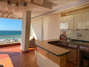 a kitchen with a view of the ocean at Direct Beachfront - Sea View 2 bed rooms in Jazīrat al Maskhūţah