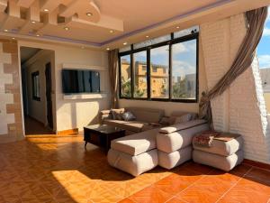 a living room with a couch and chairs and a tv at Direct Beachfront - Sea View 2 bed rooms in Jazīrat al Maskhūţah