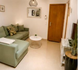 a living room with a green couch and a table at Kyel location in Ashdod