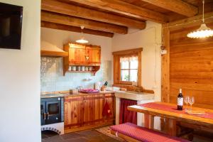 a kitchen with wooden cabinets and a stove at Baita dei Fovi in Baselga di Pinè