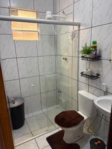 a bathroom with a shower with a toilet and a sink at Estadia rápida - Quarto 2 in Bayeux