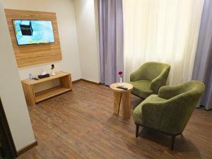 a room with two chairs and a table and a tv at فندق جادة أجياد Jada Ajyad Hotel in Ajyad