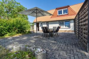 a patio with a table and an umbrella at Ankerhaus 2 in Trent