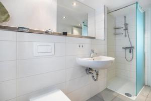 a white bathroom with a sink and a shower at Ankerhaus 2 in Trent +21 photos