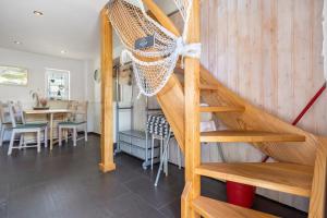 a wooden staircase in a living room with a table at Ankerhaus 2 in Trent