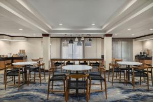 a dining room with tables and chairs in a building at Fairfield Inn & Suites by Marriott Marietta in Marietta