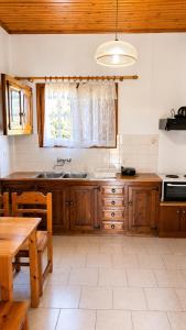 a kitchen with wooden cabinets and a sink and a table at Gian Petro Apartments in Sidari +28 photos