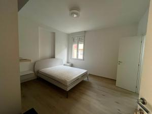 a white bedroom with a bed and a window at Bigò Apartments in Termoli