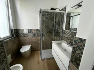 a bathroom with a shower and a toilet and a sink at Bigò Apartments in Termoli