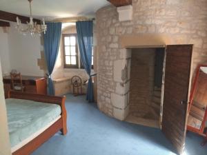 a bedroom with a stone wall with a bed and a fireplace at gite La Tour Au Comté in Charency