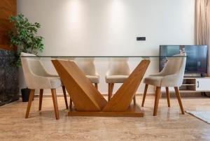 a glass table with four chairs and a television at Comfort and luxury with pool in Tamaris
