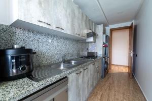 a small kitchen with a sink and a microwave at Comfort and luxury with pool in Tamaris