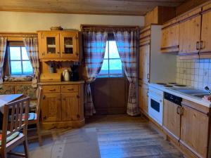 a kitchen with wooden cabinets and a table and a window at Almhütte Gipper in Heiligenblut