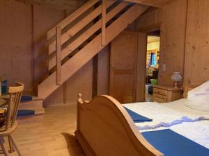 a bedroom with a bed and a wooden staircase at Almhütte Gipper in Heiligenblut