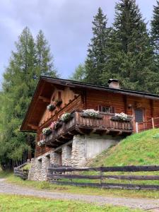 a log cabin with a balcony on a hill at Almhütte Gipper in Heiligenblut