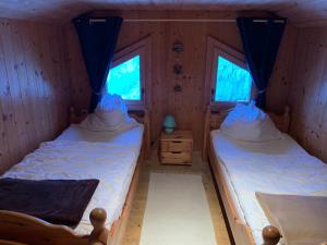 two beds in a room with two windows at Almhütte Gipper in Heiligenblut +4 photos