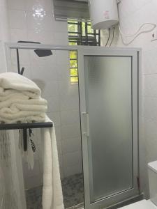 a bathroom with a glass shower door and towels at Da Palm boutique resort in Aburi +32 photos