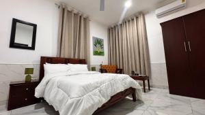 a bedroom with a bed and a chair in it at Da Palm boutique resort in Aburi