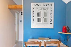 a blue room with a table and a chair at Lorali - Chambre d'Hôtes in Gohier