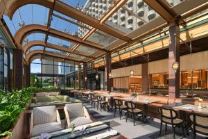 a restaurant with tables and chairs in a building at Sari Pacific Jakarta, Autograph Collection in Jakarta