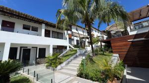 a building with stairs and a palm tree at Pousada Gammel Dansk by Latitud Hoteles in Búzios