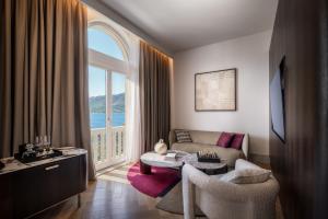 a living room with a couch and a large window at Aminess Younique Korcula Heritage Hotel in Korčula