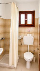 a bathroom with a toilet and a shower curtain at Gian Petro Apartments in Sidari