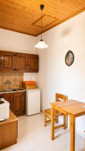 a kitchen with a table and a white refrigerator at Gian Petro Apartments in Sidari