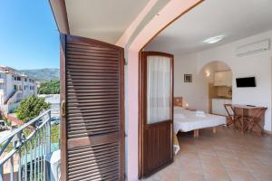 ein Zimmer mit Balkon, mit Bett und Tisch in der Unterkunft Nurache in Orosei