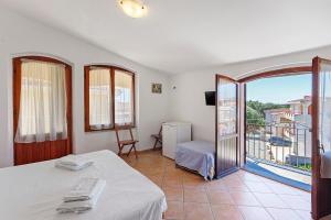 ein Schlafzimmer mit Bett und Balkon in der Unterkunft Nurache in Orosei