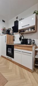 a kitchen with white cabinets and a black stove at Silverka Studio in Tarnowskie Góry