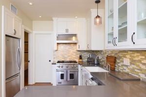 a kitchen with white cabinets and a stove top oven at Playa One Bedroom (251) in Carpinteria