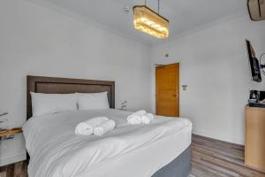 a bedroom with a bed with two towels on it at Larkey View A Tranquil Space For Two - Pass the Keys in Canterbury +5 photos