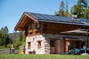 a house with solar panels on top of it at Baita dei Fovi in Baselga di Pinè