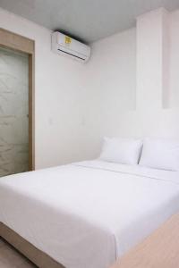 a large white bed in a white room with a air conditioner at hotel brb nature acacias in Acacías