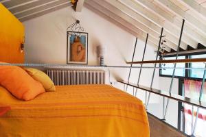 a bedroom with a bed with a yellow blanket at La Casetta del Lago in Lovere