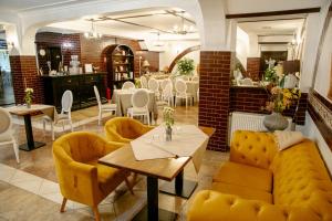 a restaurant with yellow couches and tables and a dining room at Curtea Domneasca in Vaslui +11 photos