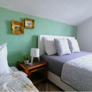 a bedroom with two beds and a table with a lamp at Villa Lila in Dolno Dupeni