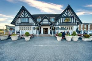 a large building with potted plants in front of it at The Greyhound Hotel in Leigh