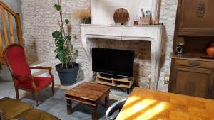 a living room with a tv and a fireplace at Têtes à l'air in Montils